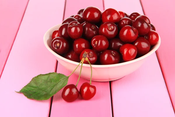 Cherry bessen in kom op houten tafel close-up — Stockfoto