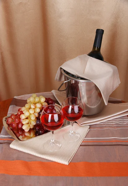 Виноград и бокалы на круглом столе на фоне ткани — стоковое фото
