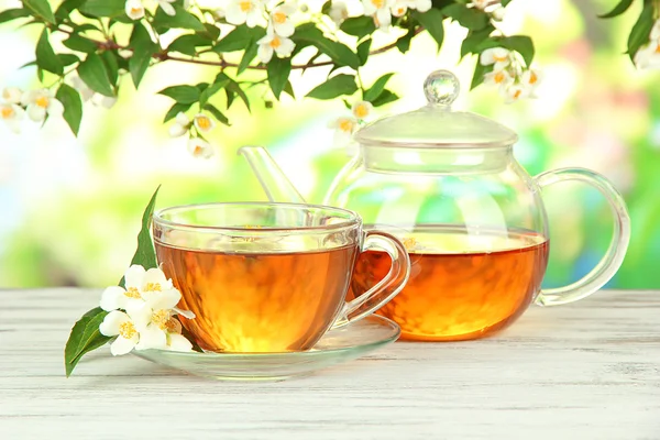 Kopje thee met jasmijn, op houten tafel, op lichte achtergrond — Stockfoto