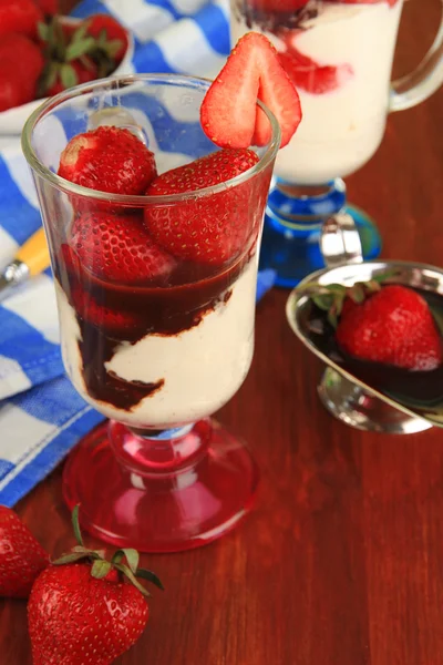 Deliziosi dessert alla fragola in vaso di vetro su tavolo di legno primo piano — Foto Stock