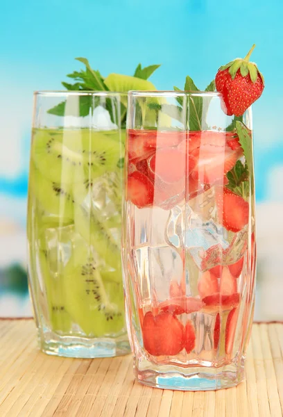水果饮料与冰蓝色背景上的多维数据集的眼镜 — 图库照片