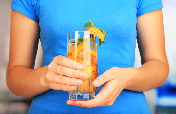 Copa de bebida de frutas con cubitos de hielo en la mano —  Fotos de Stock