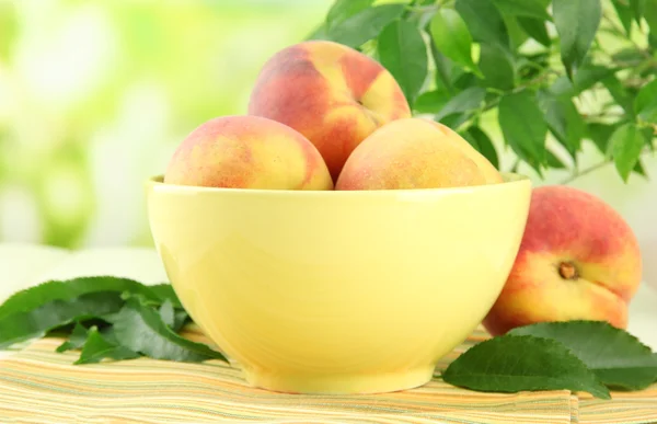 Спелые сладкие персики на столе в миске, на открытом воздухе — стоковое фото