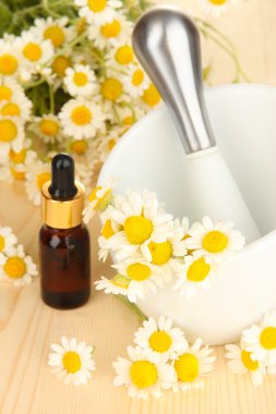 esans ve harç ahşap masa üzerinde papatya çiçeği.