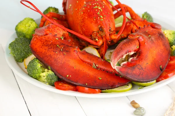 Red lobster on platter with vegetables on wooden table close-up — Stock Photo, Image