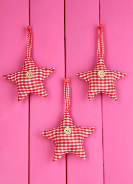 Juguetes suaves forma de estrella en tablero de madera rosa — Foto de Stock