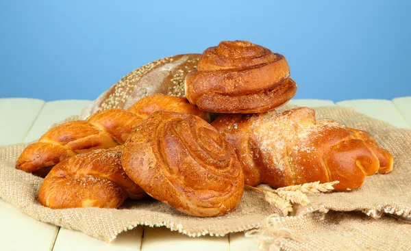 Kompozycja z chleba, toczy się w wory, na drewnianym stole, na kolor tła — Zdjęcie stockowe