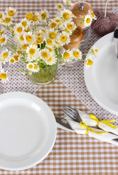 Tischdekoration mit Kamille auf karierter Tischdecke — Stockfoto