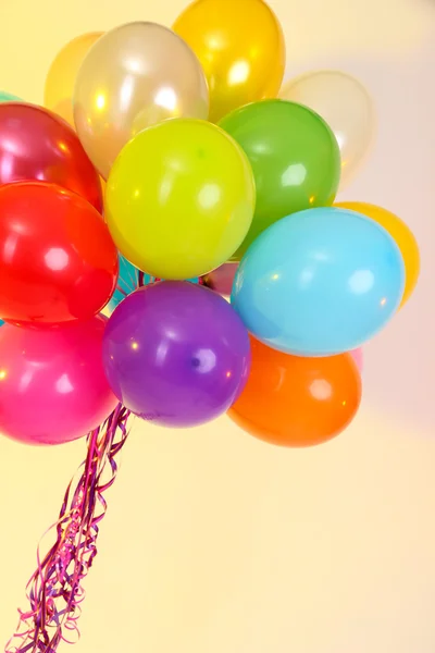 Viele helle Luftballons auf gelbem Hintergrund — Stockfoto
