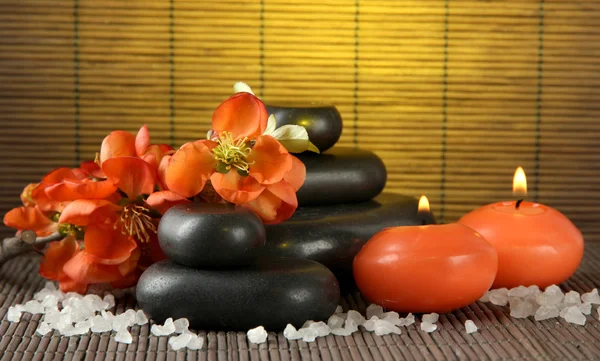 Spa stones with flowers and candles on bamboo background — Stock Photo, Image