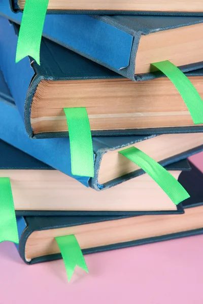 Many books with bookmarks on pink background close-up — Stock Photo, Image