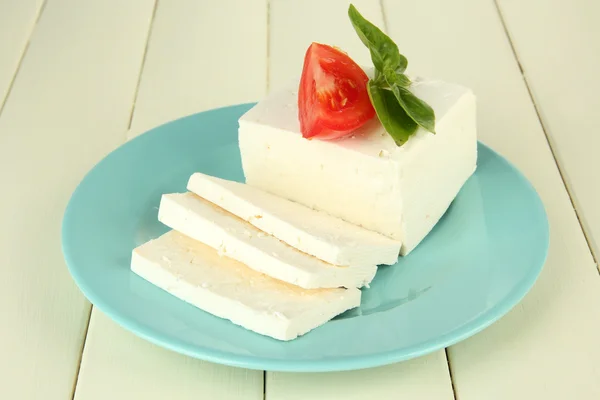 Queso de leche de oveja, con albahaca y tomate sobre fondo de madera de color — Foto de Stock