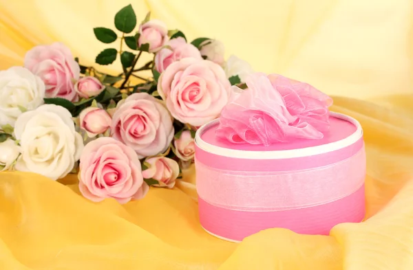 Beautiful gift on flowers background — Stock Photo, Image