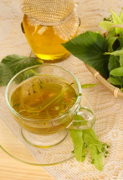 Glass cup of tea with linden on wooden table close-up — Stock Photo, Image