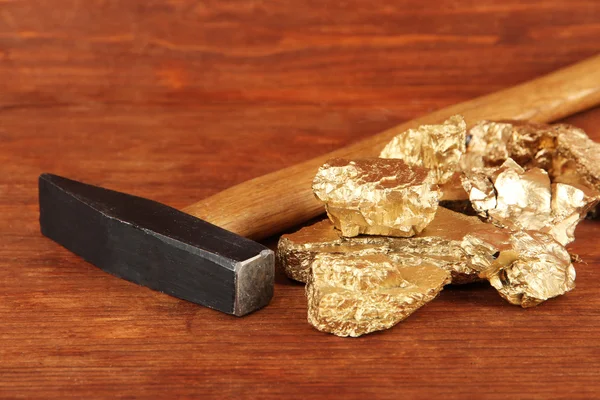 Gouden nuggets met hummer op houten achtergrond — Stockfoto