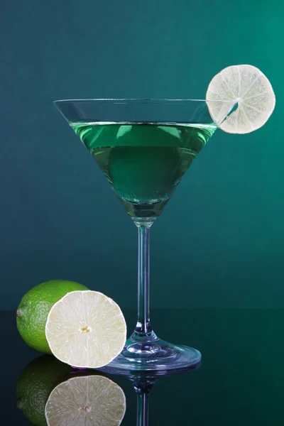 Green cocktail with lime on dark green background — Stock Photo, Image