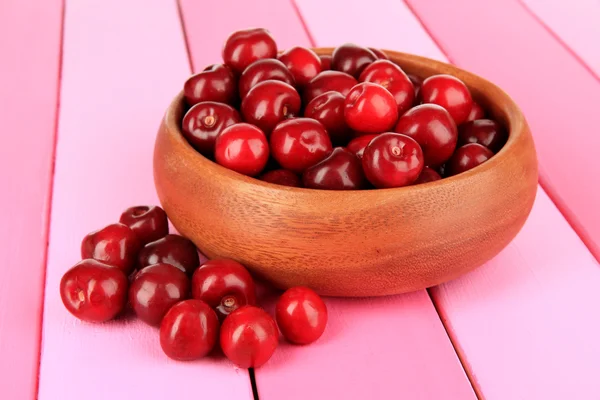 Вишневі ягоди в мисці на дерев'яному столі крупним планом — стокове фото