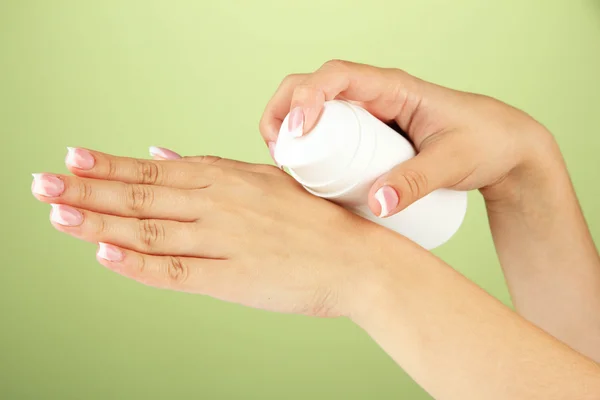 Vrouw toepassen crème op handen op kleur achtergrond — Stockfoto