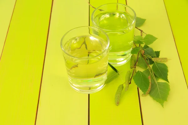 Glasses of birch sap on green wooden table — Stock Photo, Image