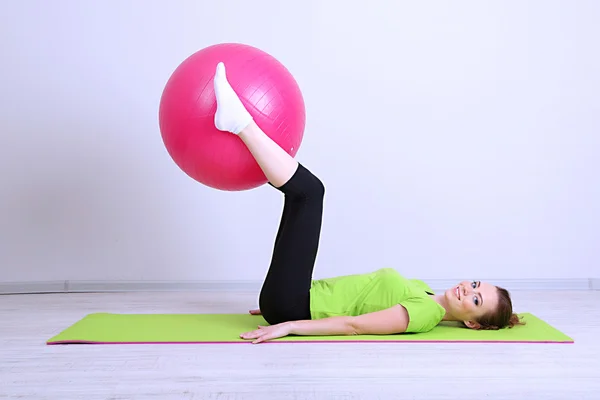 Portret van mooie jonge vrouw oefeningen met gymnastiek bal — Stockfoto