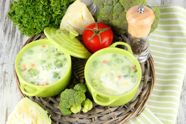 Cabbage soup in plates on braided tray on napkin on wooden table — Stock Photo, Image