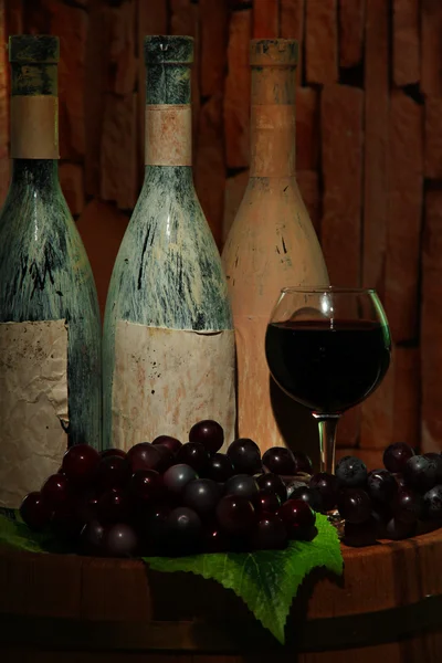 Skład z starych butelek wina i lampka w starej piwnicy, na ciemnym tle — Zdjęcie stockowe