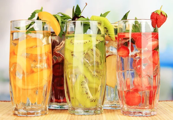 Vasos de bebidas de frutas con cubitos de hielo en la mesa en la cafetería — Foto de Stock