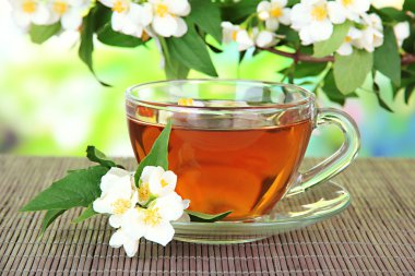 Yasemin, üzerinde parlak arka plan bambu hasır ile çay