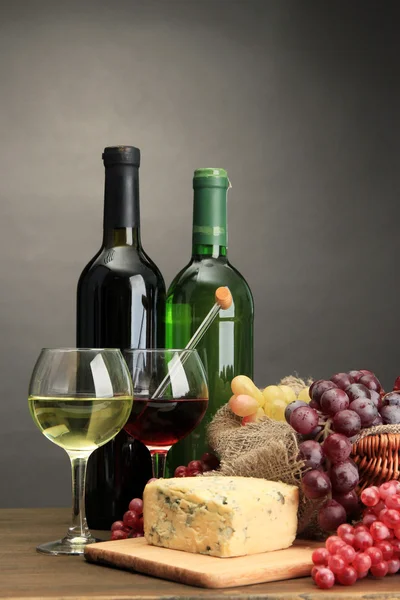 Komposition mit Wein, Blauschimmelkäse und Trauben auf Holztisch, auf grauem Hintergrund — Stockfoto