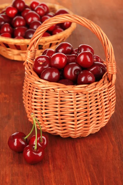 Kirschbeeren in Weidenkörben auf Holztisch in Großaufnahme — Stockfoto