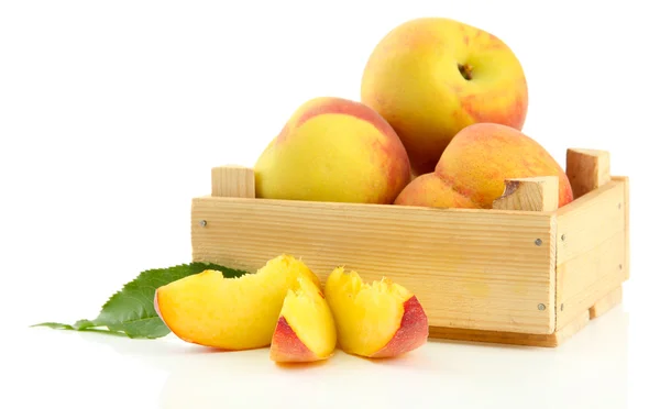Спелые сладкие персики в деревянном ящике, изолированные на белом — стоковое фото