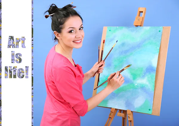 Beautiful young woman painter at work, on color background — Stock Photo, Image