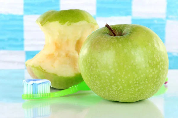 Яблоки с зубной щеткой на полке в ванной комнате — стоковое фото