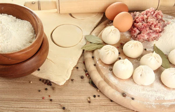 Raw dumplings, ingredients and dough, on wooden table — Stock Photo, Image