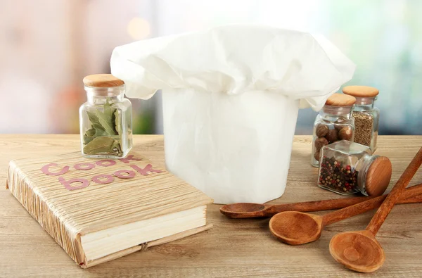 Chapeau de chef avec cuillères sur la table dans la cuisine — Photo