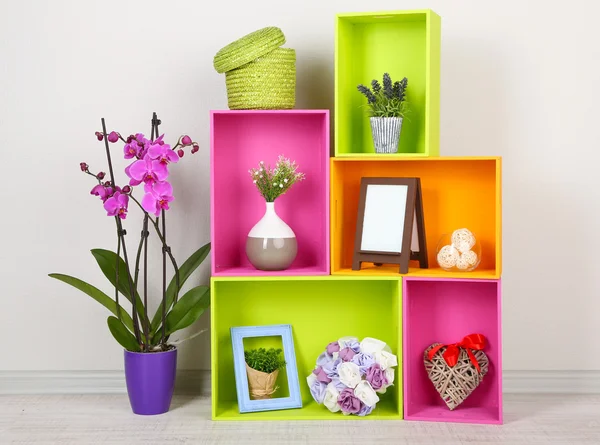 Hermosos estantes de colores con diferentes objetos relacionados con el hogar —  Fotos de Stock