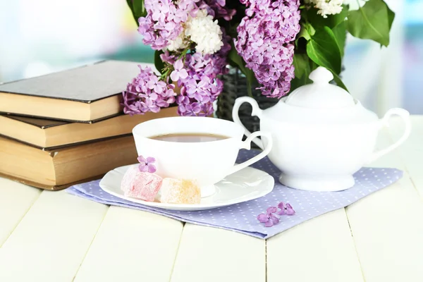 Composition avec de belles fleurs lilas, service de thé sur table en bois sur fond lumineux — Photo