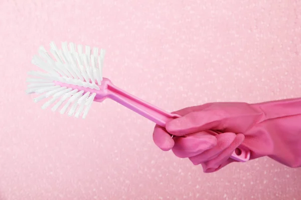 Toilet brush in hand on pink background — Stock Photo, Image