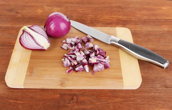 Corte de cebolla morada sobre fondo de madera — Foto de Stock