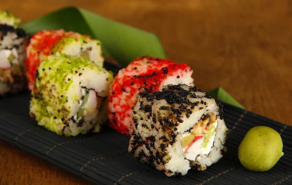 Tasty Maki sushi - Roll on mat on brown background — Stock Photo, Image