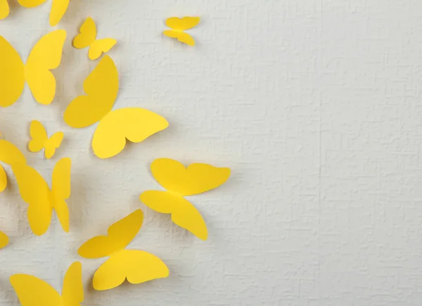 Borboletas amarelas de papel voam na parede em diferentes direções — Fotografia de Stock