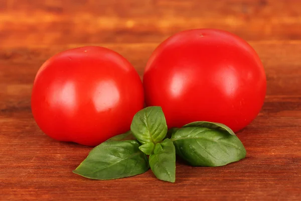 Pomidorami i bazylią na drewniane tła — Zdjęcie stockowe