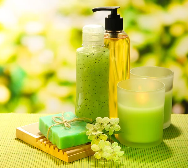 Cosmetics bottles and natural handmade soap on green background — Stock Photo, Image