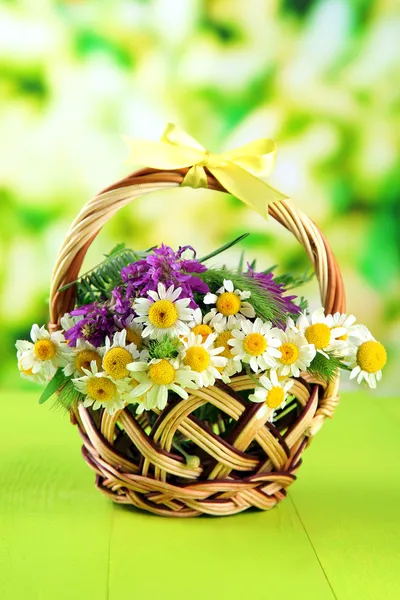 Flores silvestres y espiguillas en cesta, sobre fondo verde —  Fotos de Stock