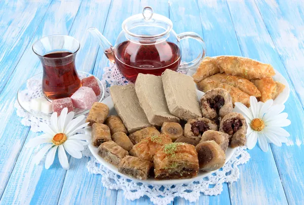 Zoete baklava op bord met thee op tafel — Stockfoto