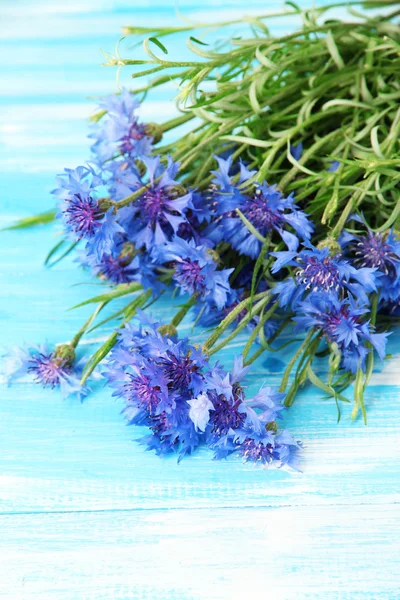 Beautiful bouquet of cornflowers on blue wooden background — Stock Photo, Image