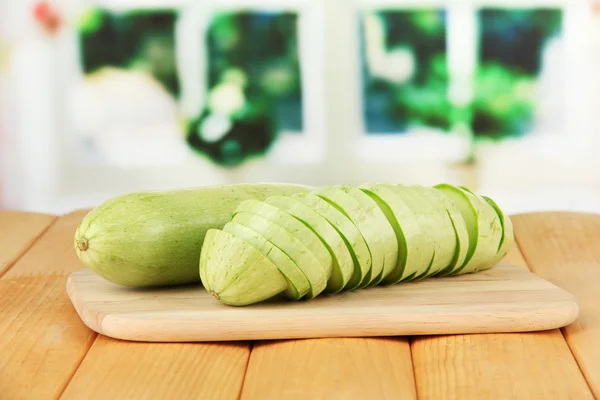 Fresh marrows on cutting board, on wooden table, on bright background — Stock Photo, Image