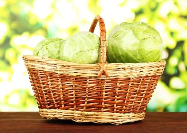 Green cabbage in wicker basket, on bright background — Stock Photo, Image