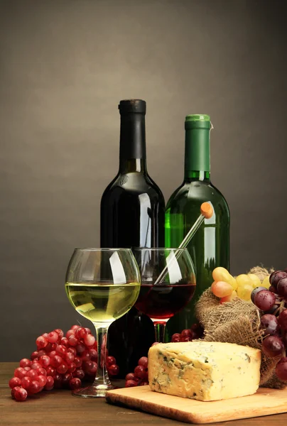 Komposition mit Wein, Blauschimmelkäse und Trauben auf Holztisch, auf grauem Hintergrund — Stockfoto