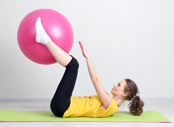 Портрет красивой молодой женщины упражнения с мячом спортзал
